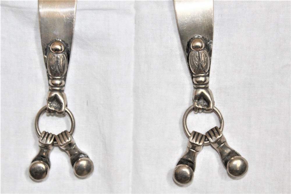 A pair of ornate late 19th-century South American metal spurs featuring multi-pointed starburst rowels and dangling charms. View IV