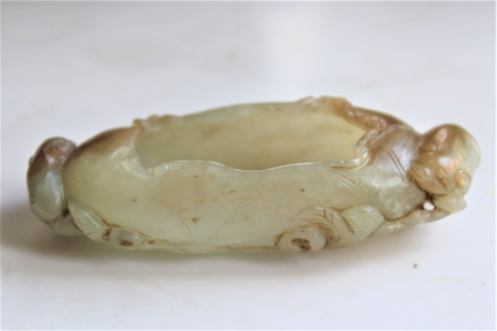 A Chinese carved jade brush washer in the form of a lily pad with an animal on each end  View IX