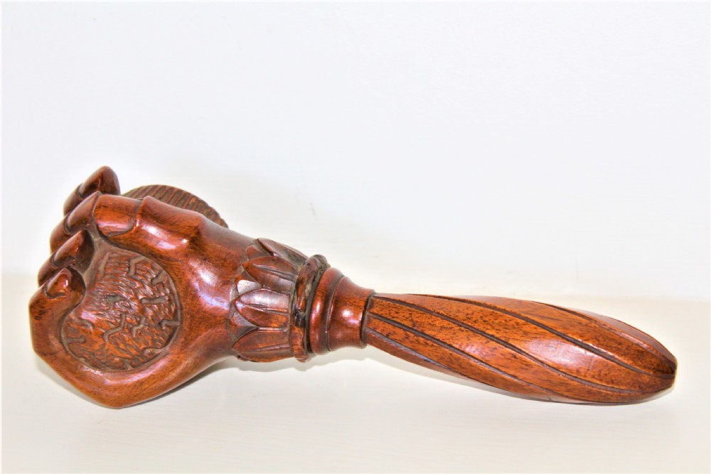 A late 19th-century carved brown wood nutcracker in the form of a clenched hand holding a nut. View IV