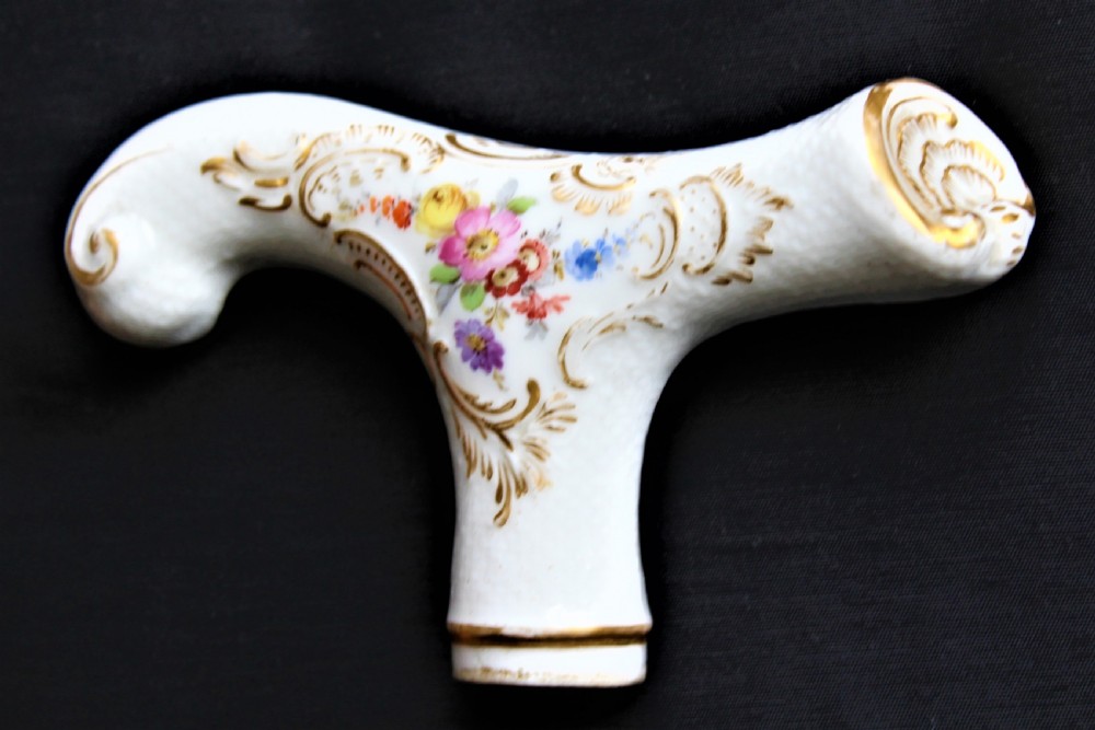 A white porcelain T-shaped walking stick handle decorated with hand-painted polychrome flowers and gilded scrolling scrollwork. View III