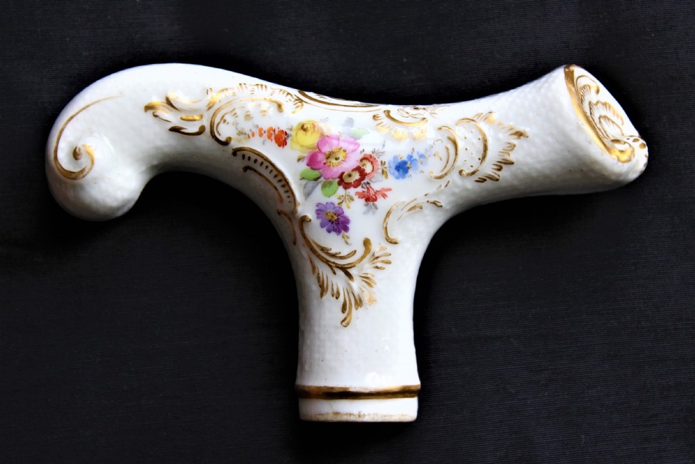 A white porcelain T-shaped walking stick handle decorated with hand-painted polychrome flowers and gilded scrolling scrollwork. View II