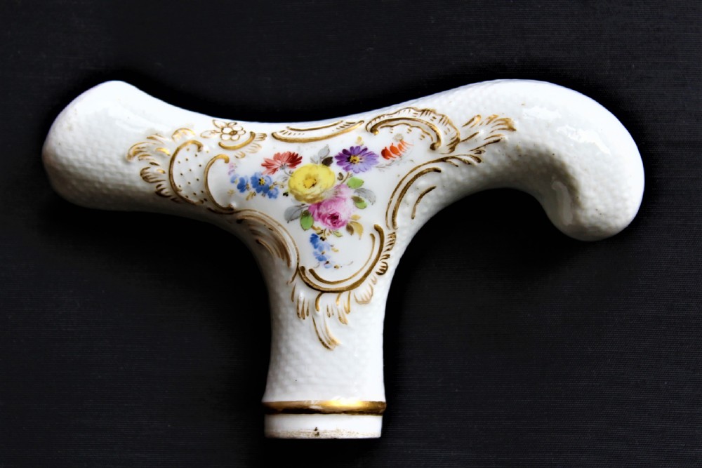 A white porcelain T-shaped walking stick handle decorated with hand-painted polychrome flowers and gilded scrolling scrollwork. View VII