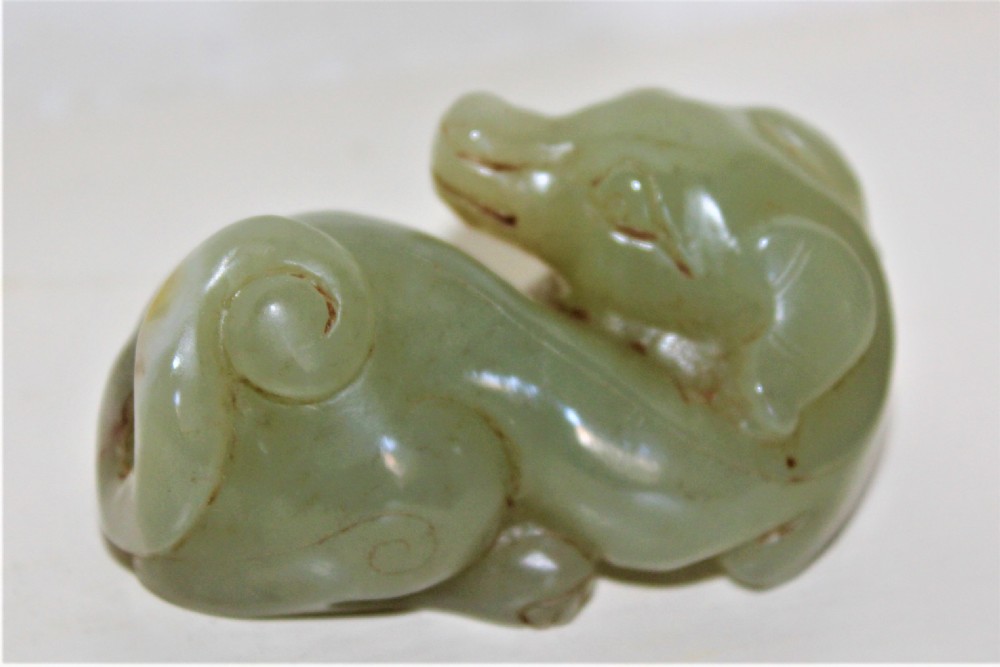 A finely carved Chinese celadon jade of a recumbent dog 