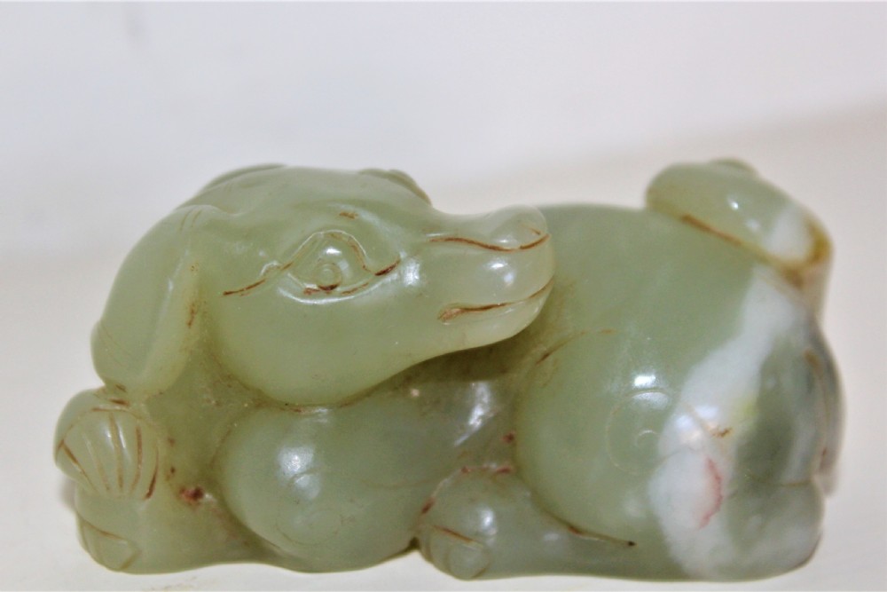 A finely carved Chinese celadon jade of a recumbent dog  View V