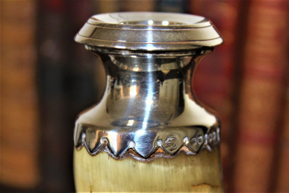 A Victorian candlestick made from a curved natural horn with a polished silver sconce rim and silver ball-footed tripod legs. View III