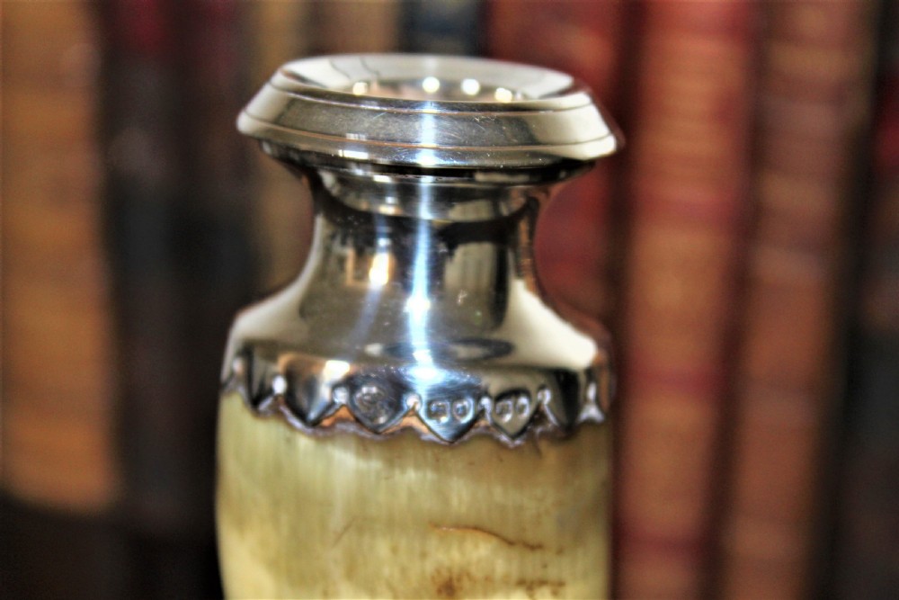 A Victorian candlestick made from a curved natural horn with a polished silver sconce rim and silver ball-footed tripod legs. View IV