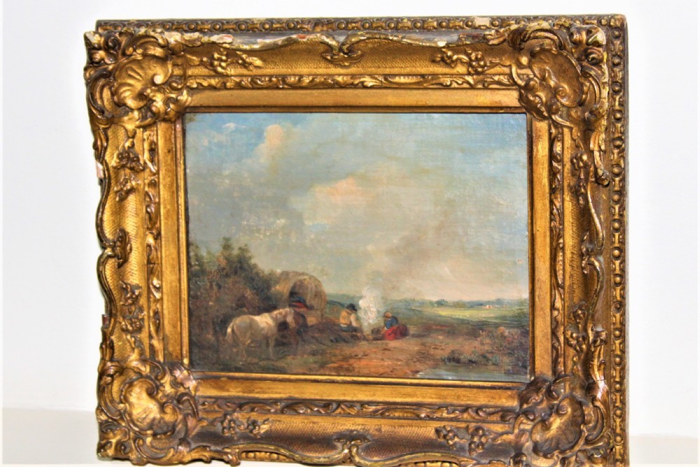 A small and charming well painted oil on panel depicting a couple sitting by a camp fire by a lake with a horse and wagon in the background  View II