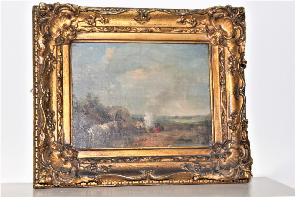 A small and charming well painted oil on panel depicting a couple sitting by a camp fire by a lake with a horse and wagon in the background  View VII