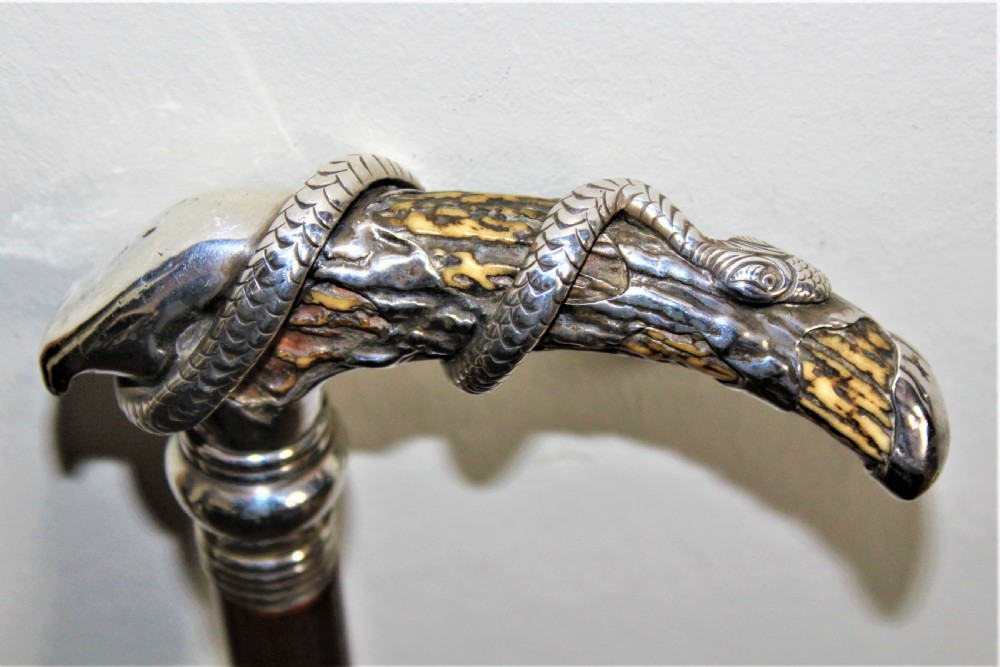 A superb bamboo walking stick the top depicting a finely cast silver snake coiled around a stag horn  Circa 1880 View X