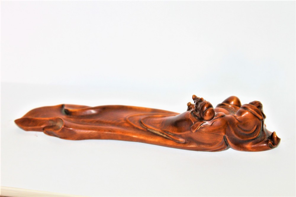 A carved Chinese boxwood wrist rest depicting a reclining bearded sage with flowing robes and a gourd bottle. View III