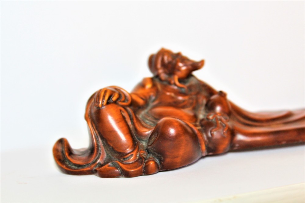 A carved Chinese boxwood wrist rest depicting a reclining bearded sage with flowing robes and a gourd bottle. View V