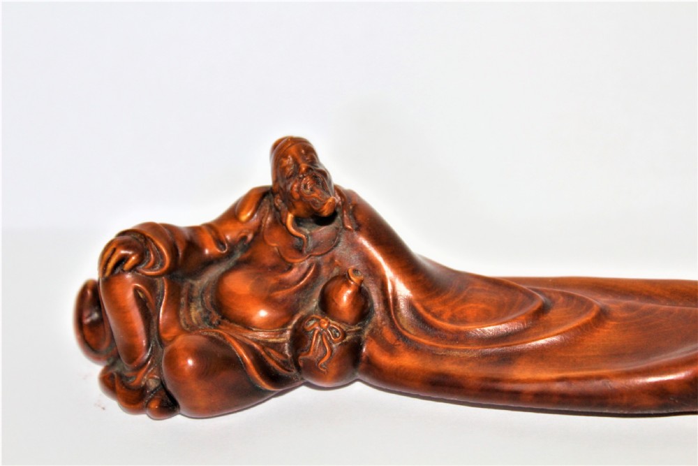 A carved Chinese boxwood wrist rest depicting a reclining bearded sage with flowing robes and a gourd bottle. View VIII