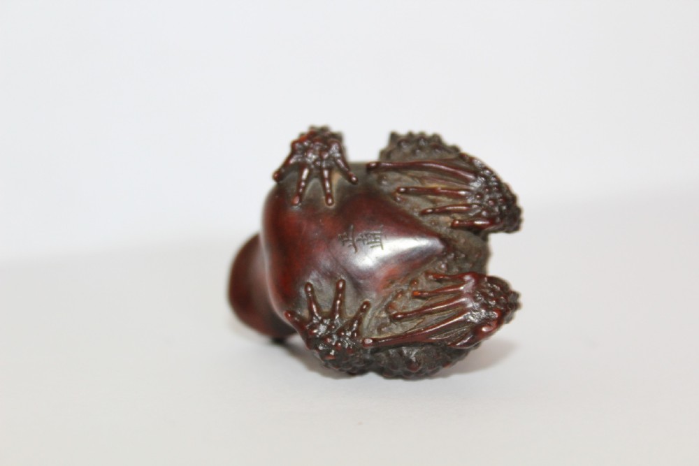 A finely carved small boxwood netsuke /okimono of two Toads signed Masanao View V