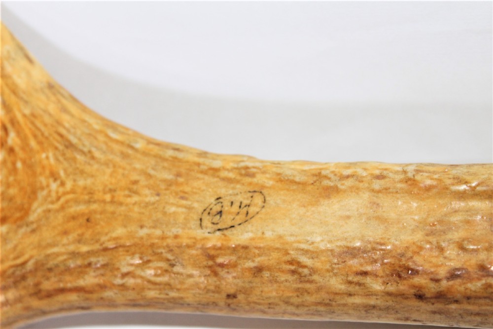 An antique cribbage board crafted from a natural stag antler featuring drilled scoring holes and incised lines. View IV