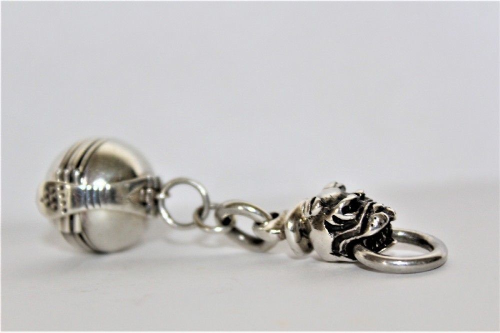 An interesting and unusual silver fob depicting a dogs head and ball 