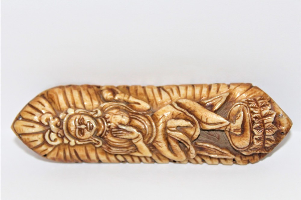 An elongated carved bone plaque depicting a standing Buddhist deity framed by an incised halo. View V