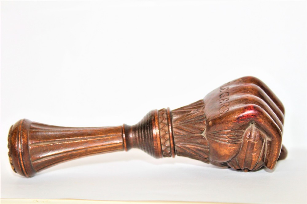 A dark brown hand-carved wooden screw-action nutcracker shaped as a clenched fist. View III
