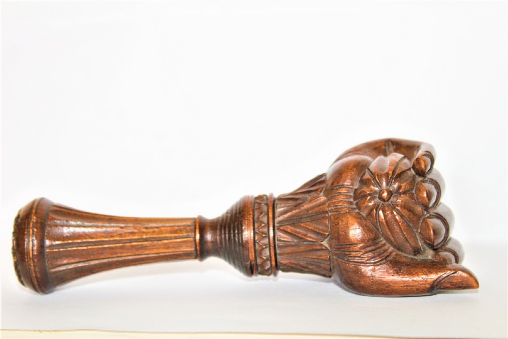 A dark brown hand-carved wooden screw-action nutcracker shaped as a clenched fist. View IV