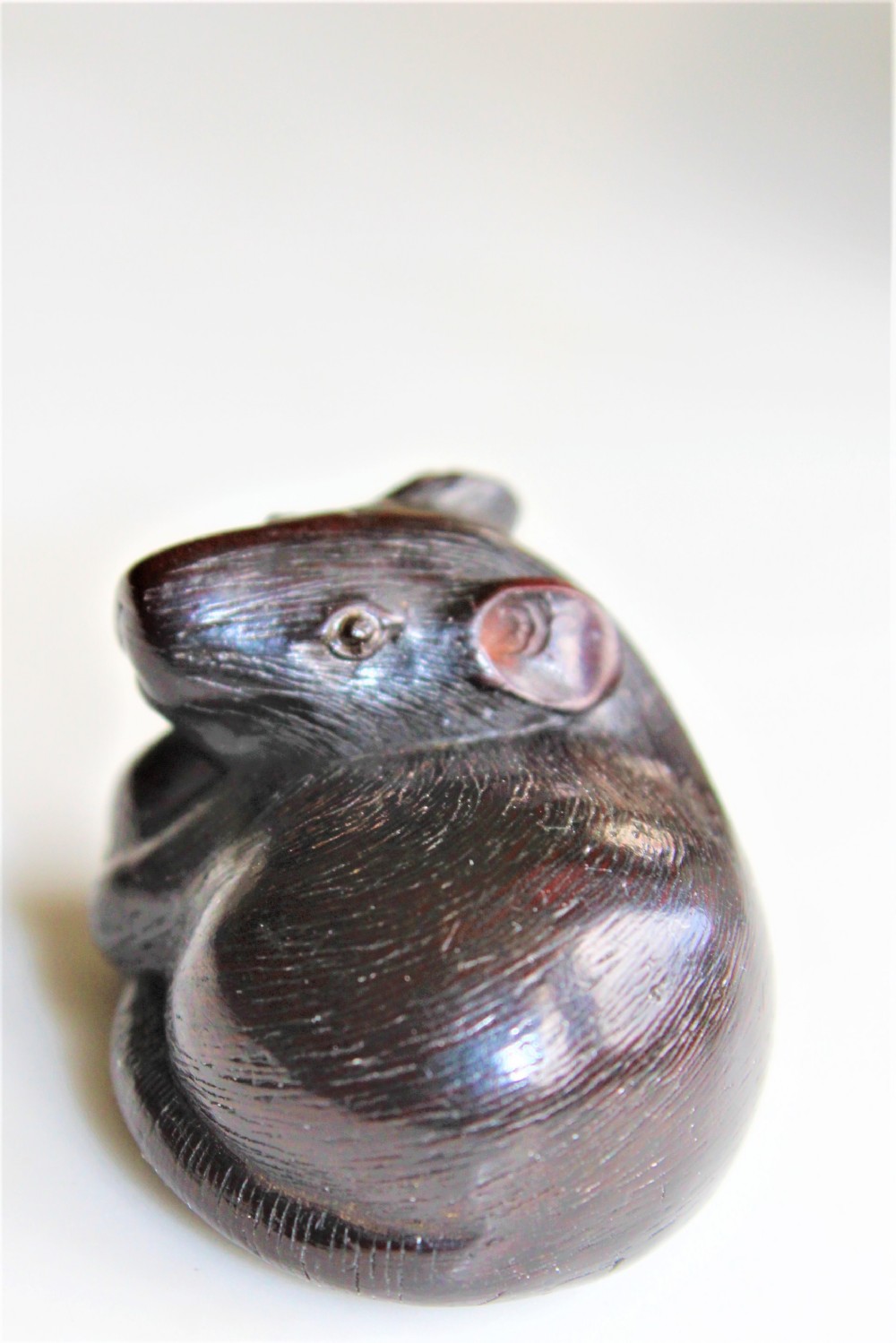 A finely carved wood netsuke modelled as a rodent