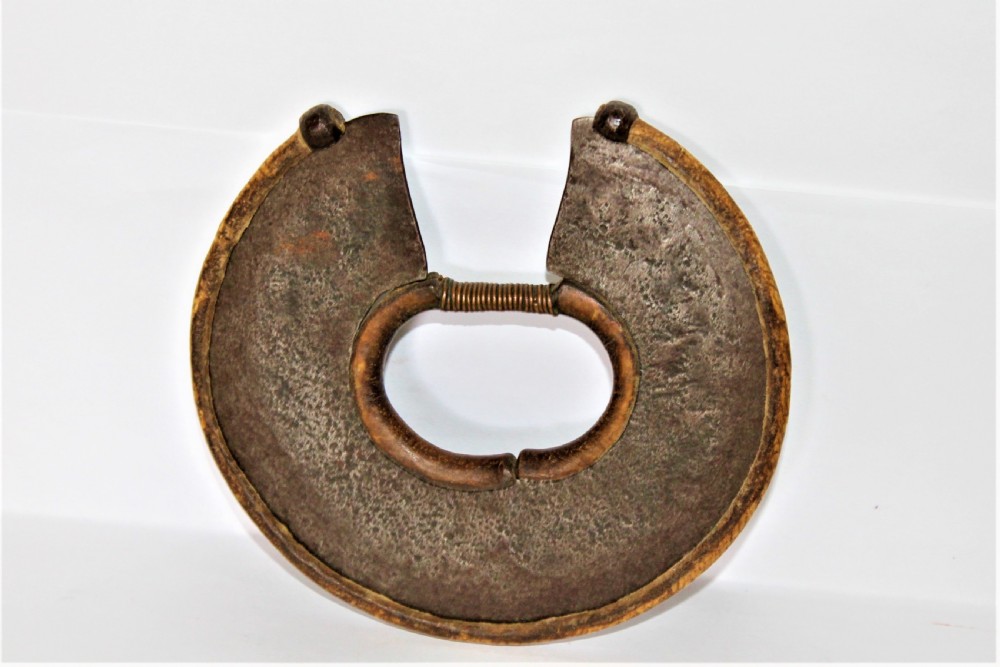 A circular hand-forged iron Turkana wrist knife featuring a stitched leather sheath covering its outer cutting edge and a wire-wrapped inner ring. View II