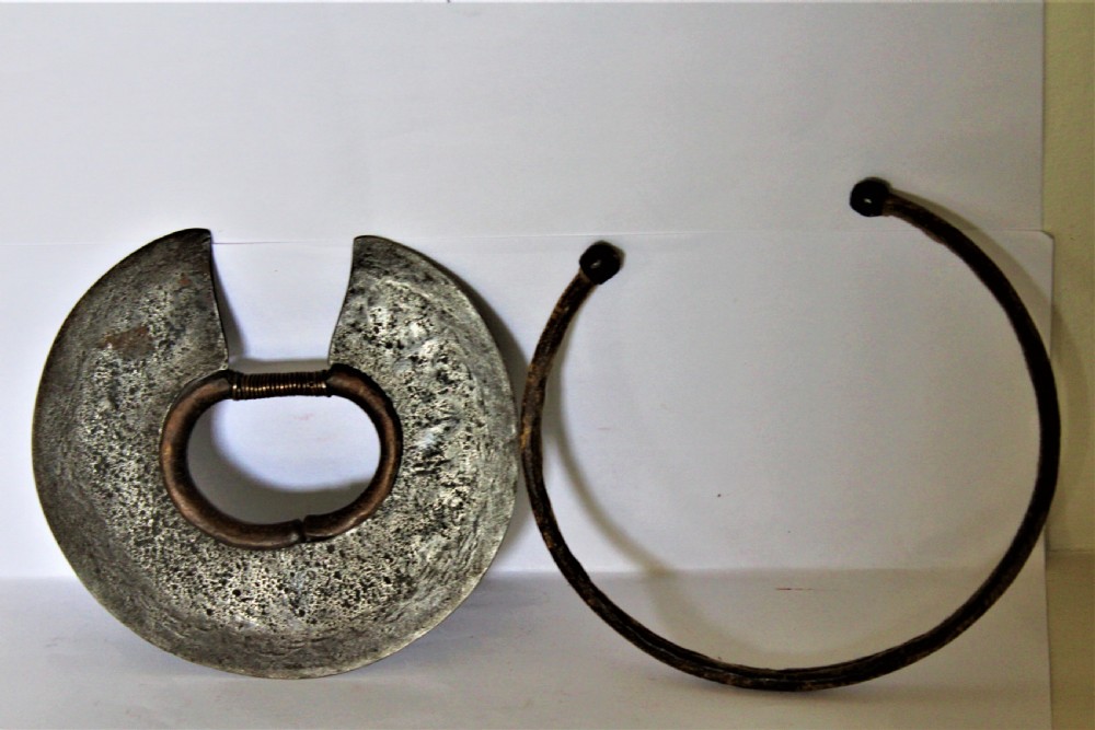 A circular hand-forged iron Turkana wrist knife featuring a stitched leather sheath covering its outer cutting edge and a wire-wrapped inner ring. View III