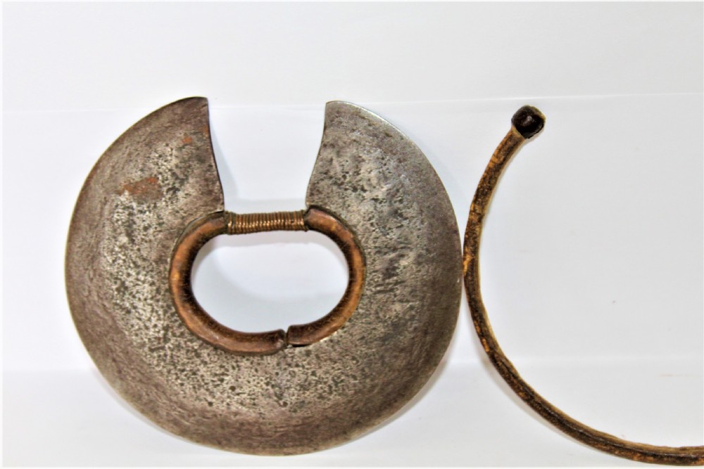A circular hand-forged iron Turkana wrist knife featuring a stitched leather sheath covering its outer cutting edge and a wire-wrapped inner ring. View IV