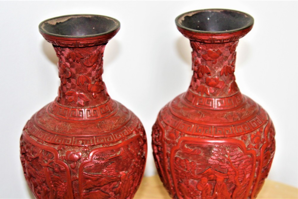 A pair of 19th-century Chinese carved red cinnabar lacquer vases featuring detailed landscape panels and geometric borders. View II