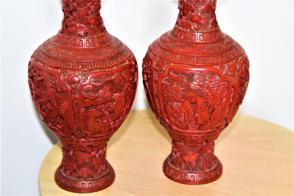 A pair of 19th-century Chinese carved red cinnabar lacquer vases featuring detailed landscape panels and geometric borders. View III