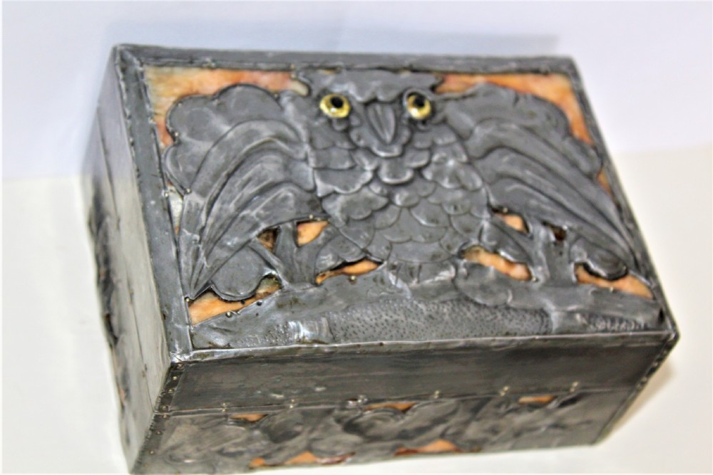 A rectangular Arts and Crafts pewter box featuring a raised repousse owl design with yellow glass eyes on the lid. View III