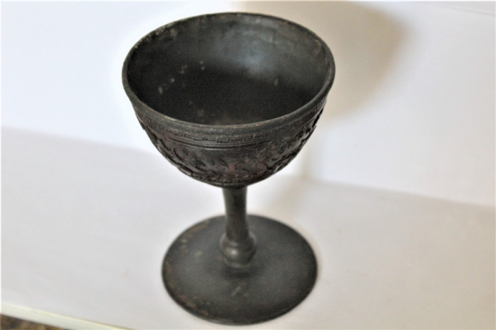 A footed Chinese goblet featuring a dark brown carved coconut shell bowl mounted on a slender pewter stem and circular base. View VII