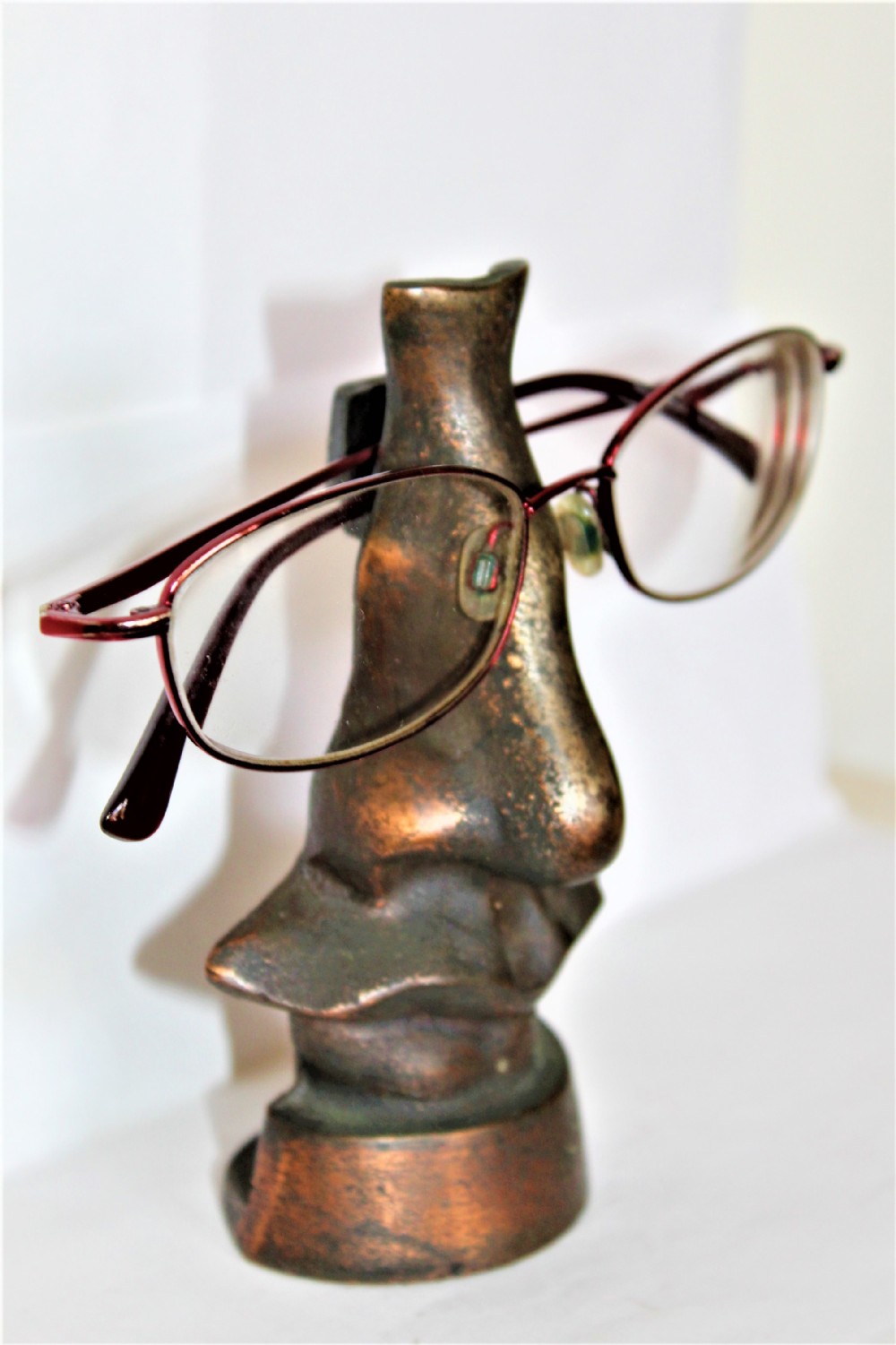 A cast metal spectacle stand in the shape of a nose
