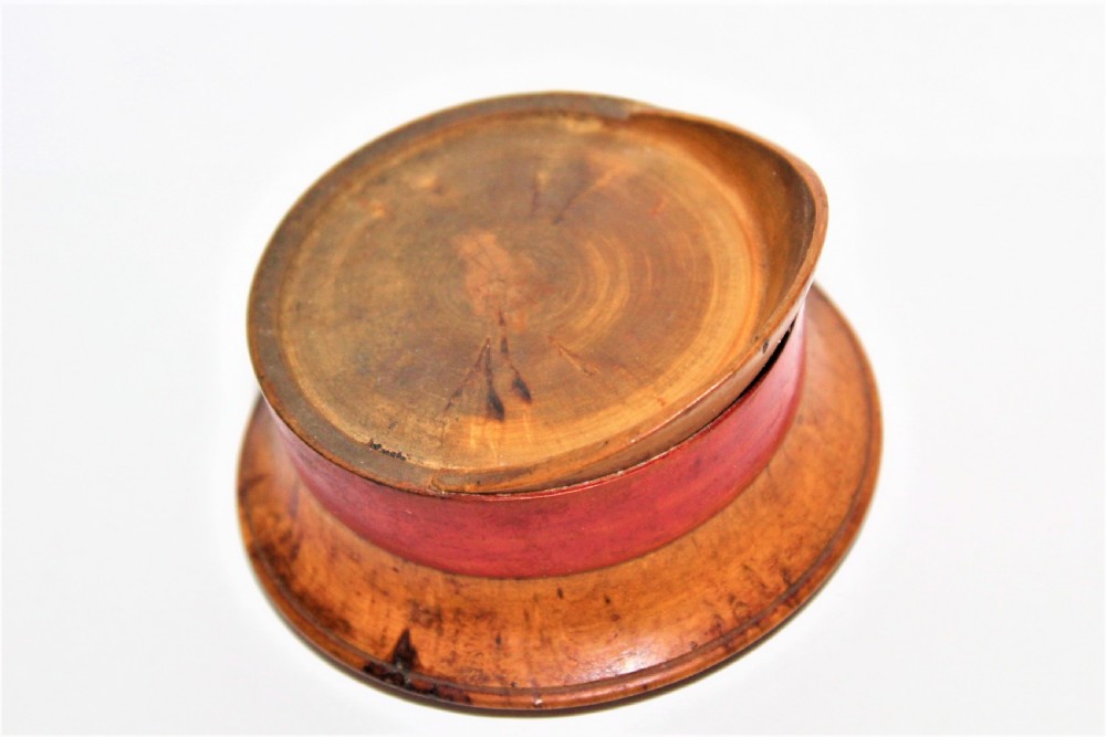 A small turned burr walnut novelty snuff box shaped like a military cap featuring a red painted central band. View VI
