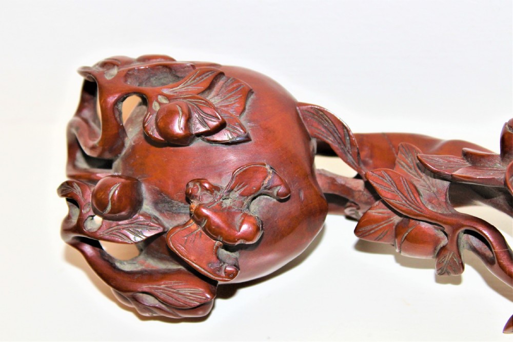 A hand-carved boxwood Ruyi sceptre featuring naturalistic branches, leaves, and peach motifs. View II