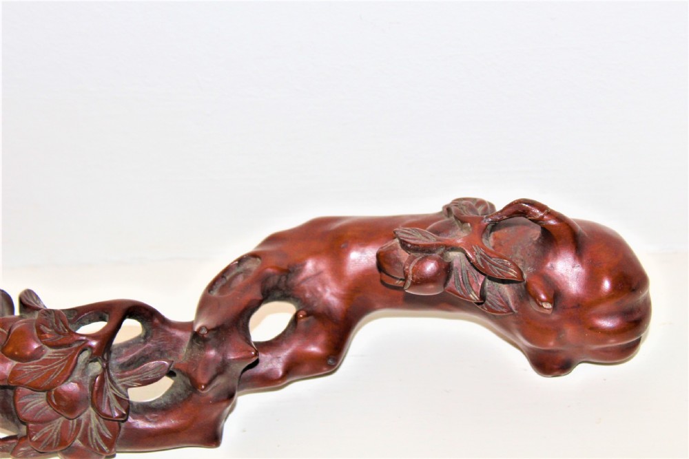 A hand-carved boxwood Ruyi sceptre featuring naturalistic branches, leaves, and peach motifs. View VII
