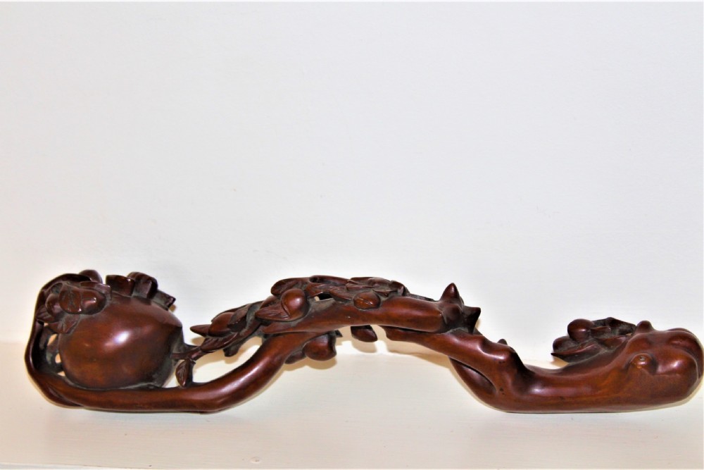 A hand-carved boxwood Ruyi sceptre featuring naturalistic branches, leaves, and peach motifs. View X