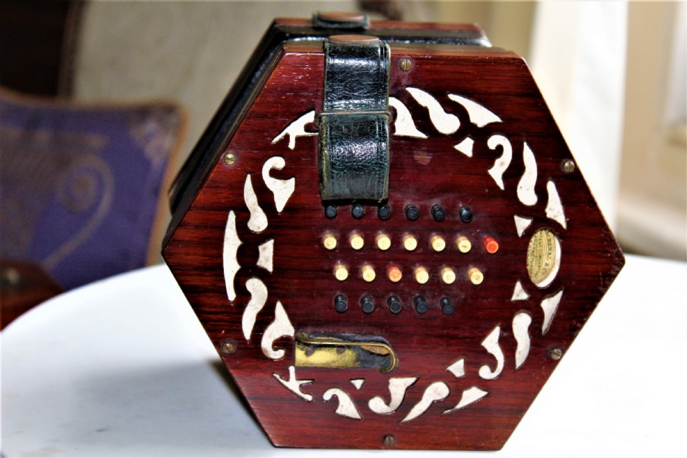 A Victorian hexagonal Lachenal button concertina featuring pierced rosewood fretwork, multi-fold leather bellows with printed paper design, and bone buttons. View XI