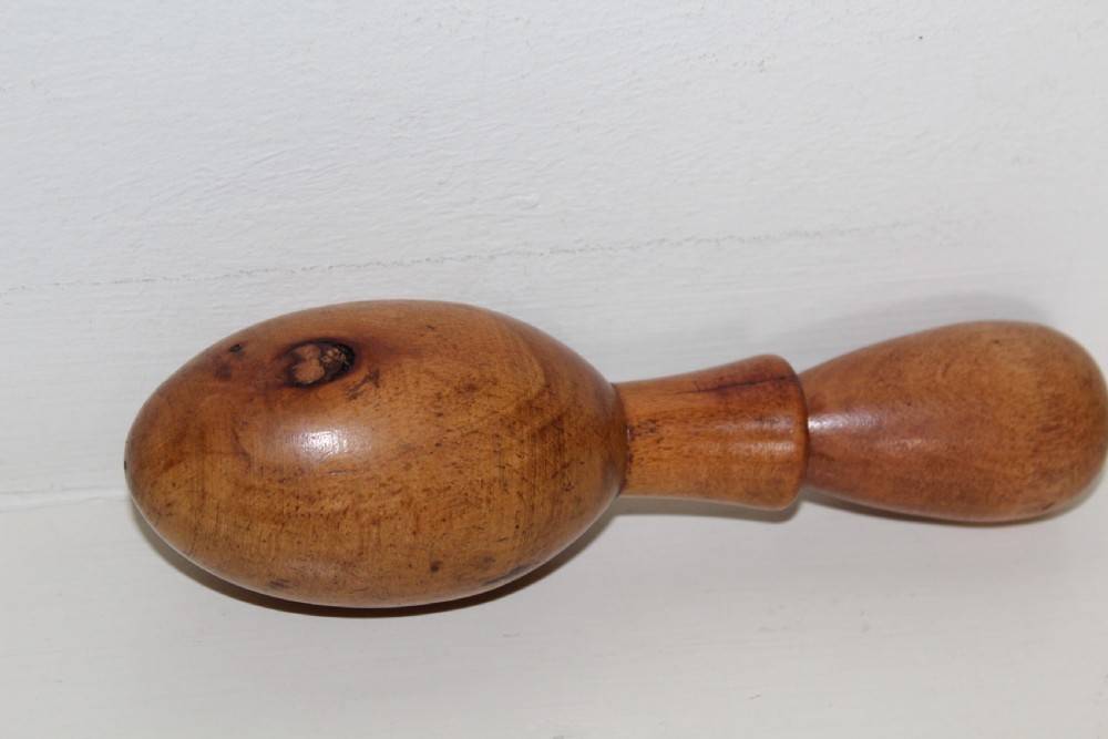 A double-ended turned wooden sock darner with two different sized rounded ends connected by a central neck. View V
