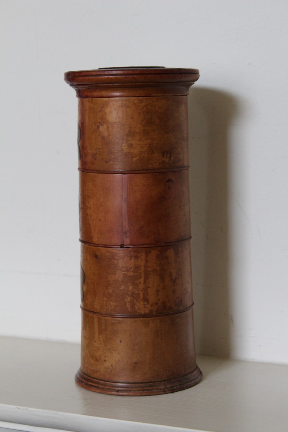 A turned wooden four-tier cylindrical spice tower with paper label banners marking Mace, Ginger, Cinnamon, and Nutmegs. View V