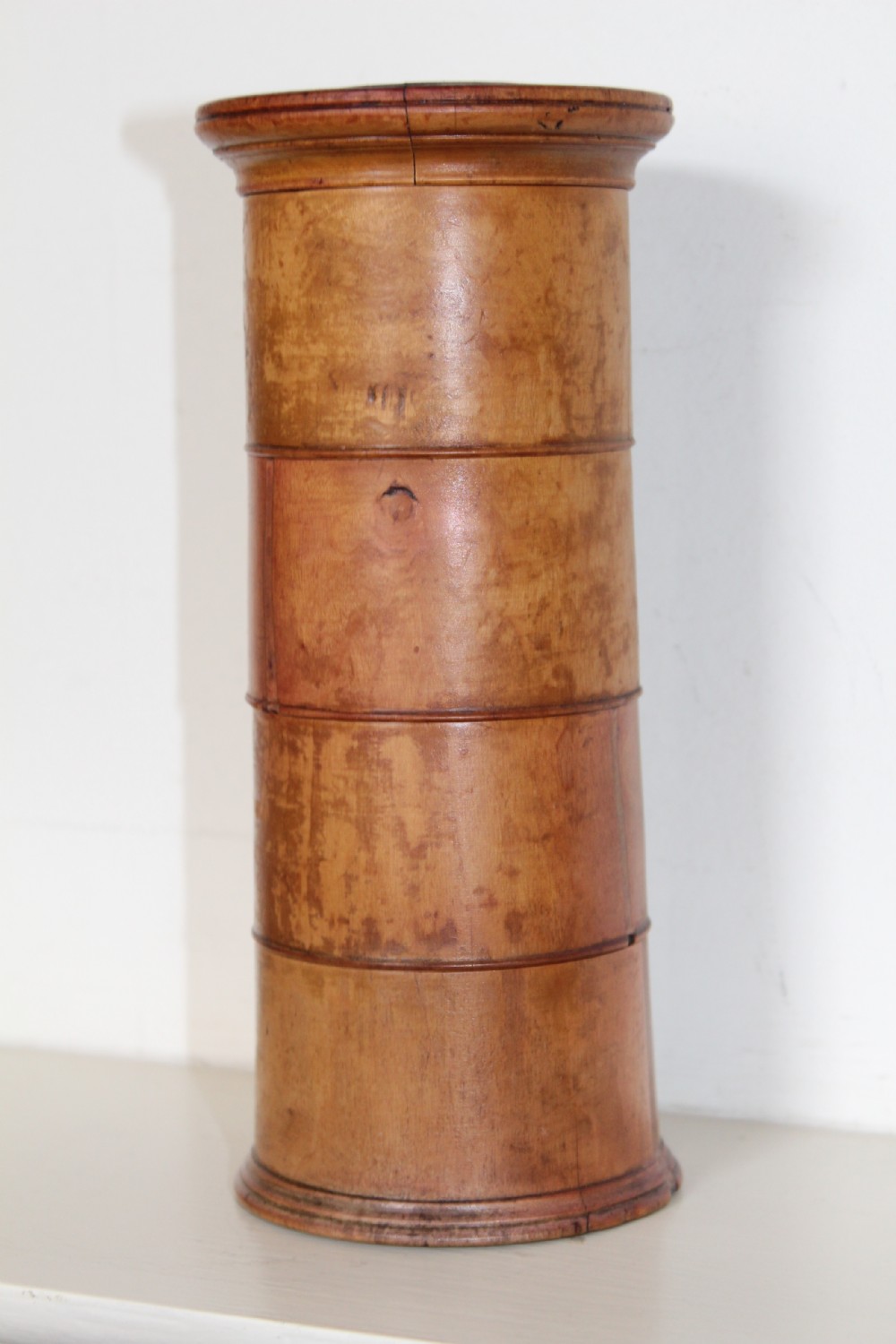 A turned wooden four-tier cylindrical spice tower with paper label banners marking Mace, Ginger, Cinnamon, and Nutmegs. View VIII