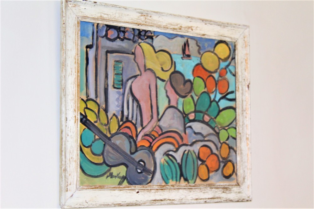 A framed expressionist oil painting depicting stylised figures, a guitar, and fruit against a coastal blue backdrop within a painted white wooden frame. View II