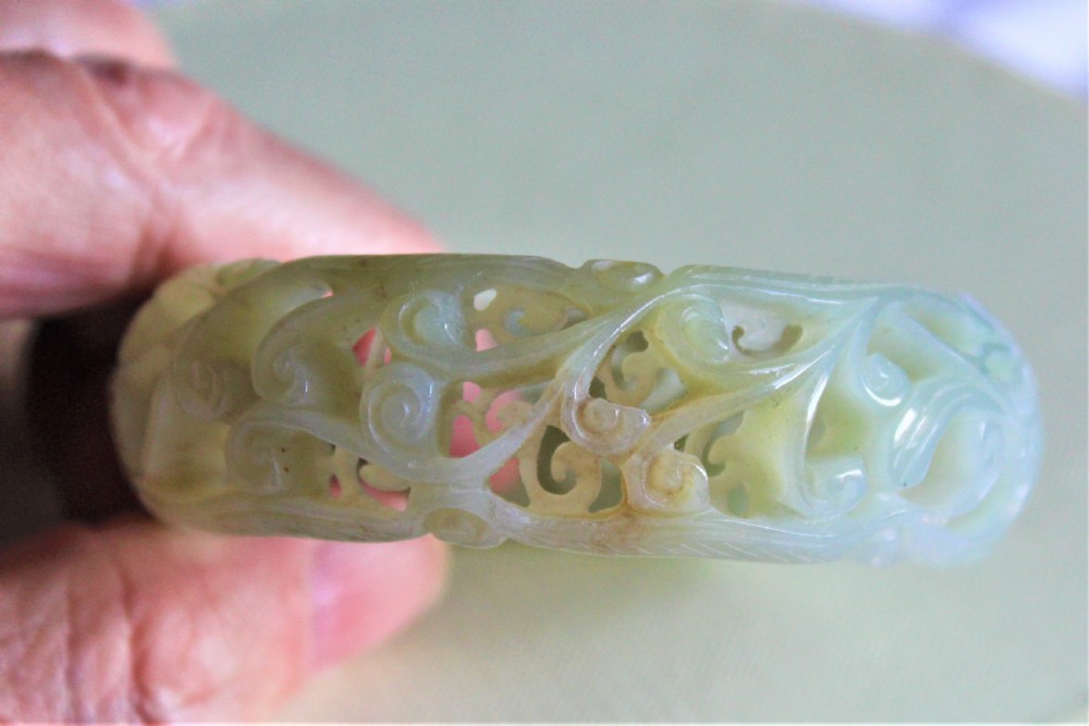 A very fine and deeply carved Chinese celadon jade bangle  View II