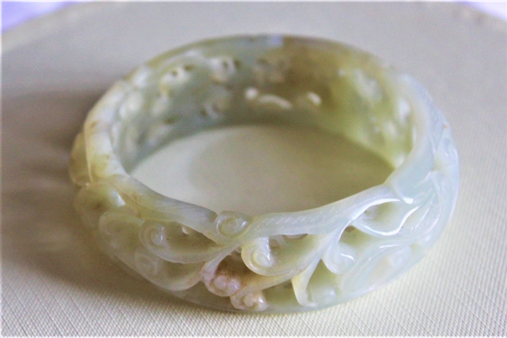 A very fine and deeply carved Chinese celadon jade bangle  View V