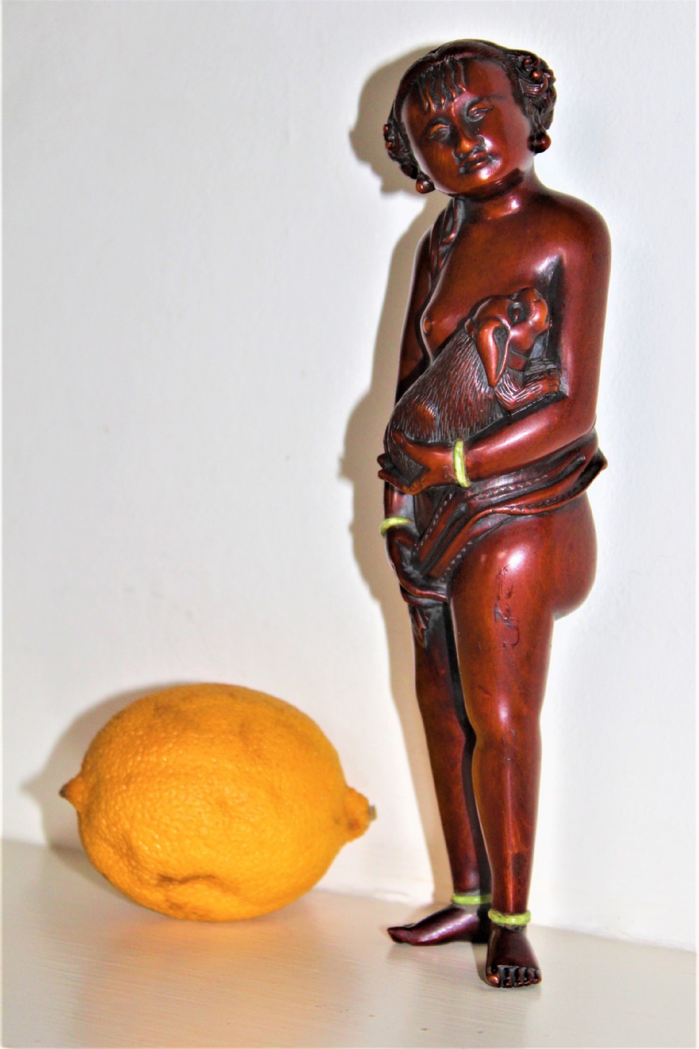 A finely carved large boxwood netsuke of a young girl