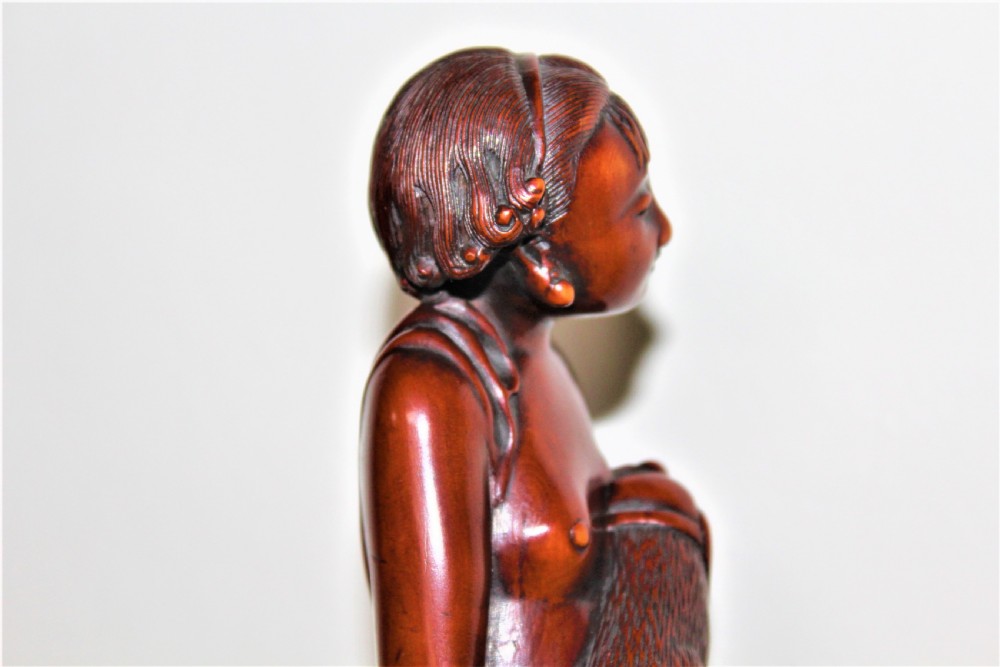 A finely carved large boxwood netsuke of a young girl View VII