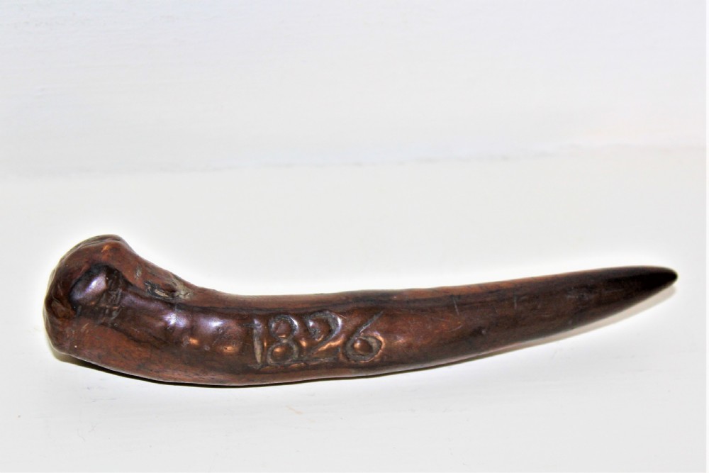 An early 19th-century curved wooden sailors fid featuring the carved date 1826 on its smooth polished body.