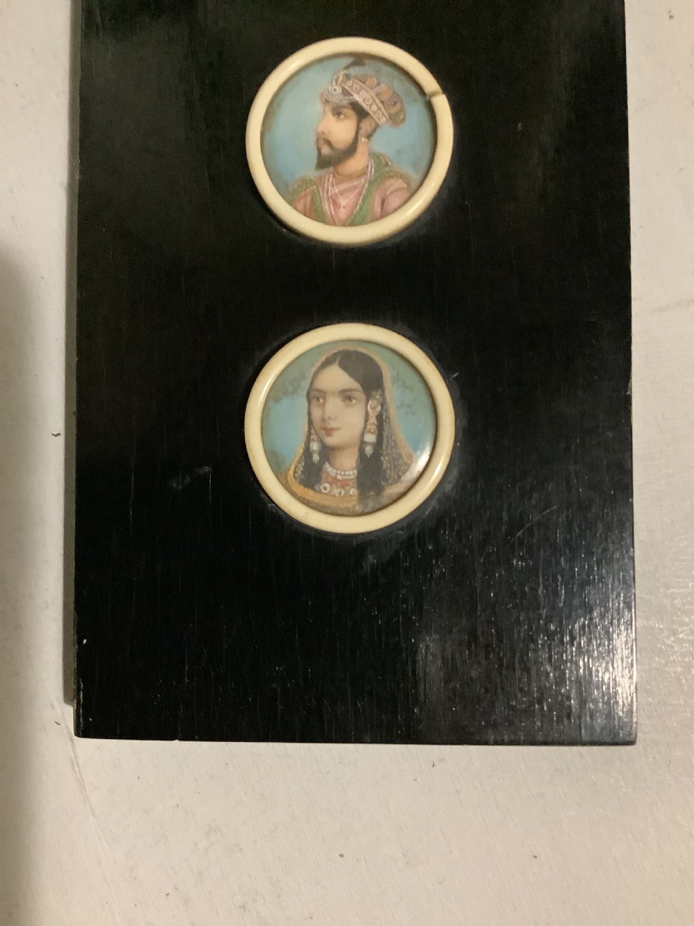 A small Indian ebonised wood painting of three miniatures finely painted on the back of the glass View V