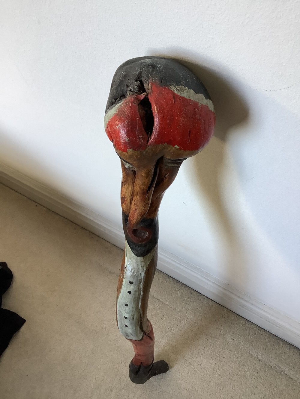 A hand-carved polychrome thorn wood walking stick featuring an anthropomorphic head and a painted red and grey shaft. View IV