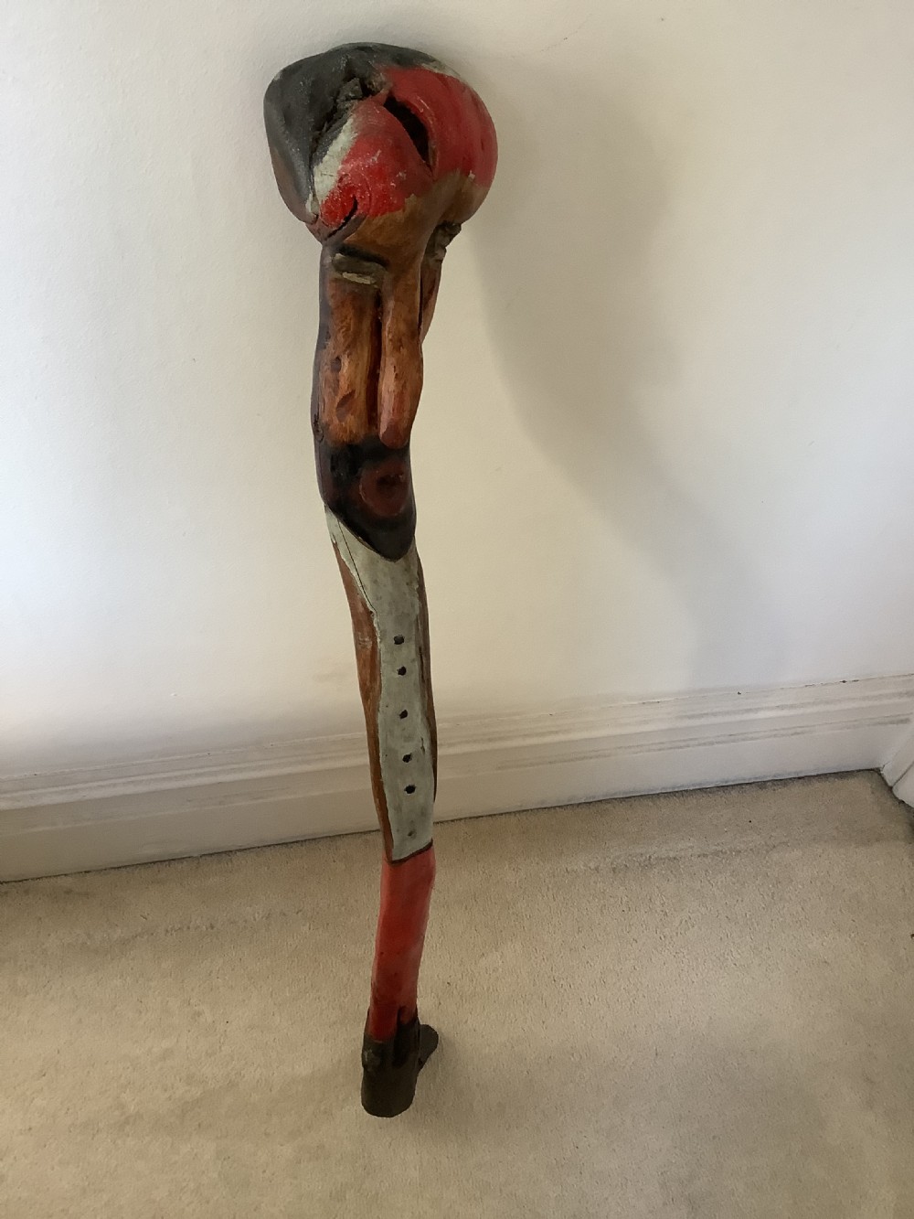 A hand-carved polychrome thorn wood walking stick featuring an anthropomorphic head and a painted red and grey shaft. View VIII