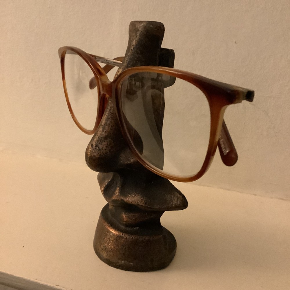 An unusual bronzed cast metal spectacle stand