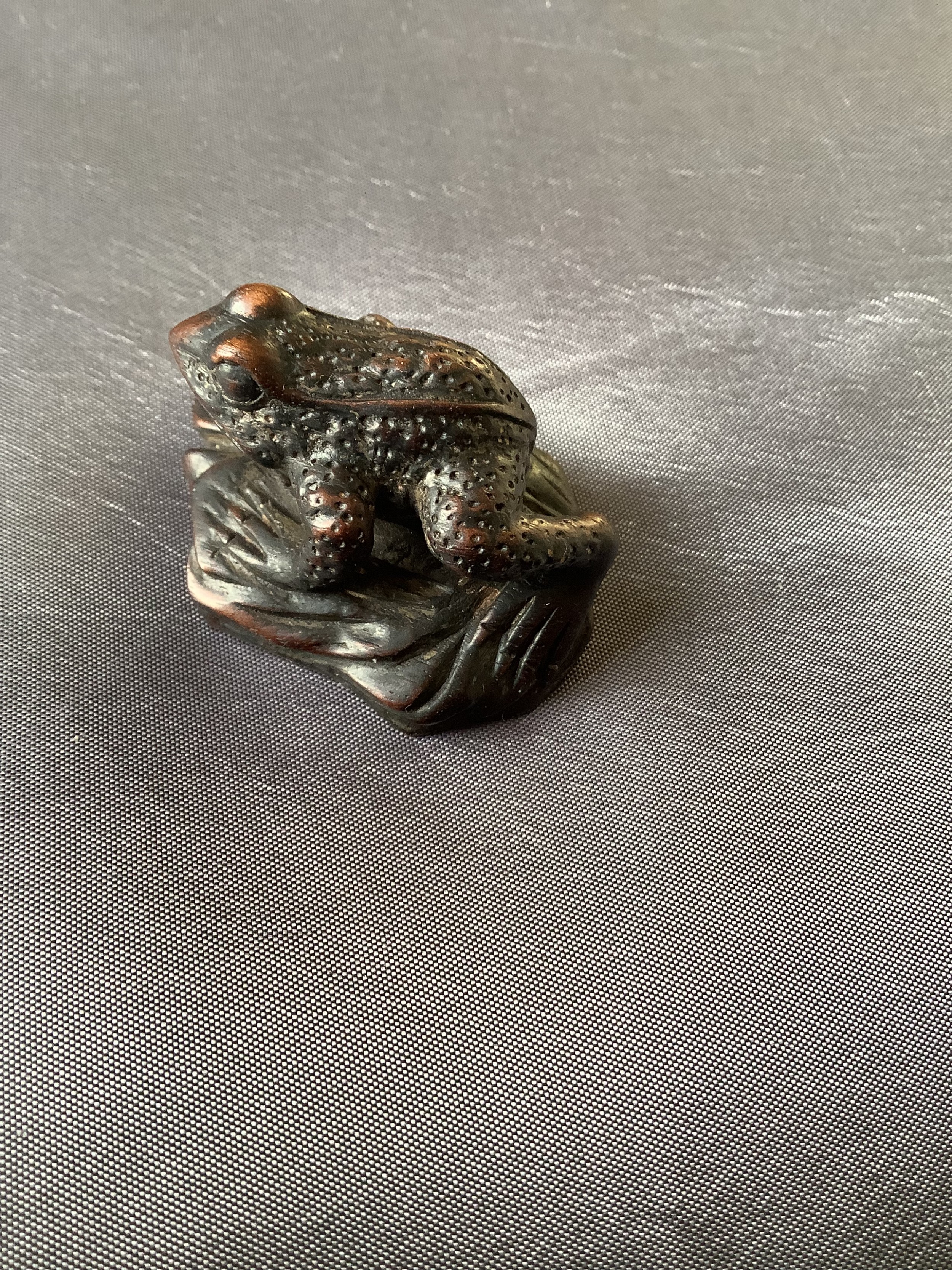 A finely carved small wood netsuke of a frog 